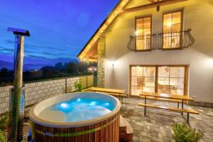 a jacuzzi tub on a patio in front of a house at Chalet West - Zuberec in Zuberec