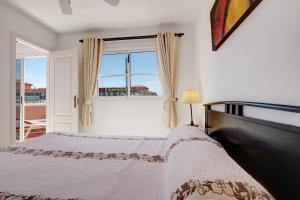 ein Schlafzimmer mit einem Bett und einem Fenster in der Unterkunft Beautiful 3 bed Apartment in Caleta de Fuste + 14 Fotos