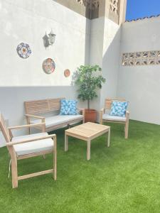 a patio with three benches and a table and a plant at Casita Estrella con entrada independiente y patio in La Estrella