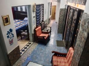 um corredor com cadeiras e uma cama num quarto em Doha Guest House 