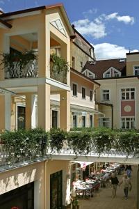 un edificio con un balcón con plantas. en Apartmany Cesky Dvur, en Mariánské Lázně