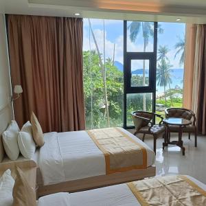 a hotel room with a bed and a large window at One El Nido Suite in El Nido
