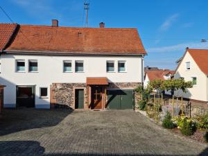 a large white house with a driveway at Gästehaus Iwwerdorfer Hof in Büdingen