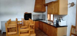 uma cozinha com armários de madeira e um balcão preto em Maison cœur tarentaise em Les Chapelles