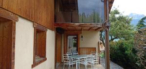 eine Terrasse mit einem Tisch und Stühlen auf einer Veranda in der Unterkunft Maison cœur tarentaise in Les Chapelles