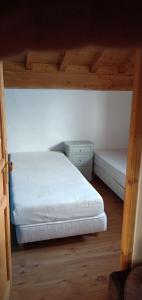 um quarto com uma cama e uma mesa de cabeceira e uma cama sidx sidx sidx em Maison cœur tarentaise em Les Chapelles