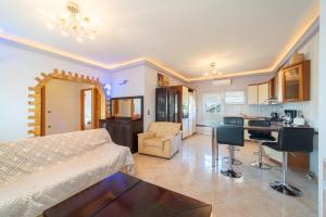 Una sala de estar con una cama y una cocina. en Panorama House Petritis, en Petrití
