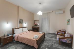 een hotelkamer met een bed en een stoel bij Remvi Hotel - Apartments in Stoupa