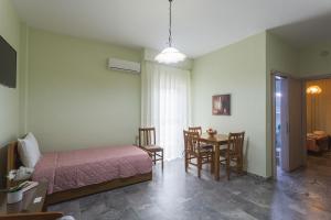 a bedroom with a bed and a table and chairs at Remvi Hotel - Apartments in Stoupa