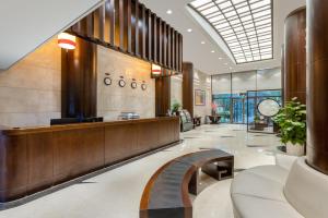 a lobby with a reception desk and a bench at Belgravia Serviced Residence Wuxi in Wuxi