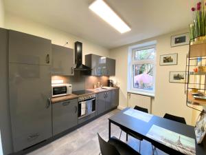 a kitchen with stainless steel appliances and a table at Kamoro in Trier