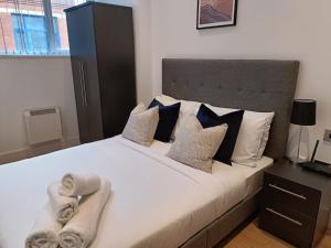 1 dormitorio con 1 cama grande y toallas. en Stunning mill apartment near to city centre and Etihad stadium!, en Mánchester