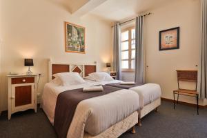 a bedroom with two beds and a window at Hôtel Playa in Saint-Tropez