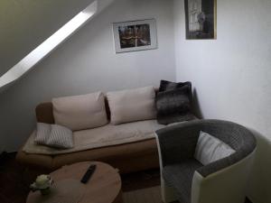 uma sala de estar com um sofá e uma cadeira em Gästehaus Natterer - FeWo 2 em Momlingen