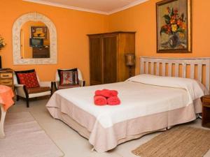 a bedroom with a bed with two red towels on it at KAROOWERF GUEST HOUSE in Cradock