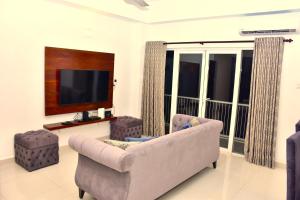 a living room with a couch and a flat screen tv at BNB RESIDENCIES NAWALA in Nawala