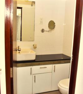 a bathroom with a sink and a toilet and a mirror at BNB RESIDENCIES NAWALA in Nawala