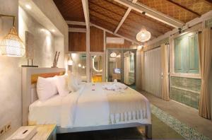 a bedroom with a large white bed in a room at Casa Batu Belig in Seminyak