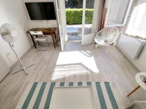 uma sala de estar com uma televisão e uma mesa e cadeiras em Appartement Six-Fours-les-Plages, 2 pièces, 4 personnes - FR-1-316-232 em Six-Fours-les-Plages