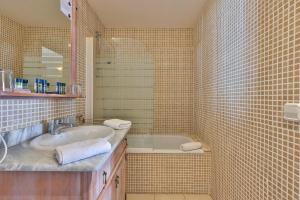 a bathroom with a sink and a bath tub at H&ocirc;tel Playa in Saint-Tropez