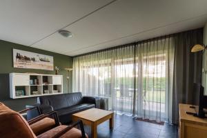 ein Wohnzimmer mit einem Sofa und einem Fenster in der Unterkunft Waddenresidentie Ameland in Buren