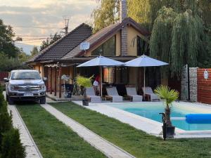 a car parked in front of a house with a pool at Paradise Resort in Miercurea-Ciuc