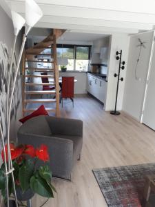 ein Wohnzimmer mit einem Sofa und einer Küche in der Unterkunft Het Tuffel Huuske ( Het Aardappelhuisje ) in Haaksbergen