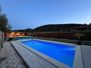 - une piscine d'eau bleue dans l'arrière-cour dans l'établissement Paradise Resort, à Miercurea-Ciuc