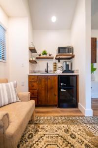 a living room with a couch and a kitchen at The Wren Treehouse 15 MIN to Magnolia Baylor 