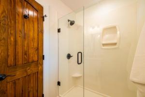 uma casa de banho com um chuveiro e uma porta de vidro em The Wren Treehouse 15 MIN to Magnolia Baylor 