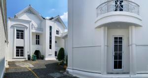 a white building with a balcony on top of it at Madina Inn Hotel in Yogyakarta