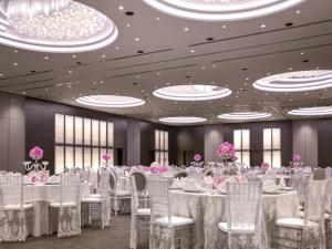 a banquet hall with white tables and chairs and pink flowers at The Art Hotel & Resort in Manama +275 photos