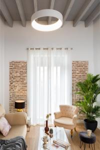 salon z dwoma krzesłami i stołem w obiekcie One&lux Puerta Osario w Sewilli