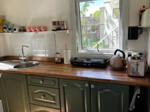 a kitchen counter with a sink and a window at Lynbrook Cabin and Hot Tub, New Forest in Ringwood