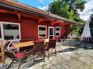 a wooden table and chairs in front of a house at Ferienhaus _Am Hexenstieg_ in Rübeland