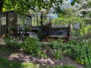 einen Garten mit einer Bank und einem Haus in der Unterkunft Lynbrook Cabin and Hot Tub, New Forest in Ringwood