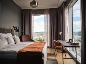 una camera d'albergo con un letto, una scrivania e una finestra di Quality Hotel Match a Jönköping