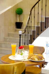 Hotel de la Poste في Kasbah: طاولة مع طبق من الخبز وعصير البرتقال