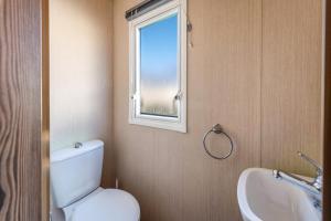 a bathroom with a toilet and a sink and a window at Waterside, Thorpe Park Cleethorpes Static Caravan in Cleethorpes
