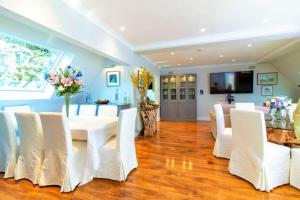 a dining room with a white table and white chairs at The luxury Beach property - Oceanbreeze in Sandgate