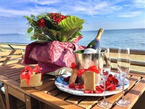 a picnic table with a bottle of wine and flowers at The luxury Beach property - Oceanbreeze in Sandgate