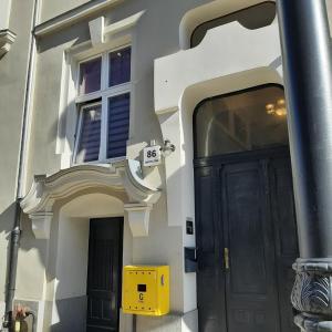 a building with a black door and a yellow box at Apartament u Olechny in Bydgoszcz