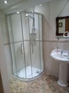 ein Bad mit einer Dusche und einem Waschbecken in der Unterkunft Charming, wonderfully cosy one bedroom apartment in Giggleswick