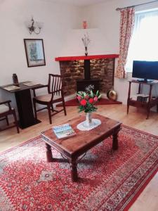a living room with a table and a fireplace at Charming, wonderfully cosy one bedroom apartment in Giggleswick