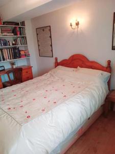 a bedroom with a white bed with red flowers on it at Charming, wonderfully cosy one bedroom apartment in Giggleswick