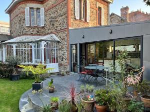 un patio con piante e un tavolo di fronte a un edificio di Maison d'exception en plein coeur de Nantes a Nantes