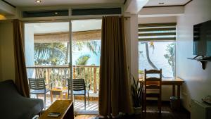 a living room with a large window and a table and chairs at DiveGurus Boracay Beach Resort in Boracay