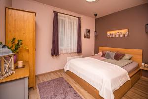 1 dormitorio con cama y espejo en Csicsergő Vendégház en Nagymaros