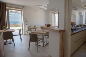 a kitchen and dining room with a table and chairs at Daedalium in Marina di Palma