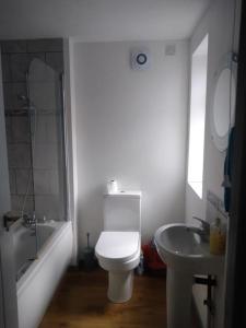 een witte badkamer met een toilet en een wastafel bij Cosy 3 bedroom house close to beach in Lowestoft